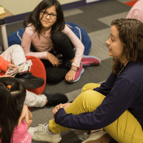 Young woman speaking to a group of young girls