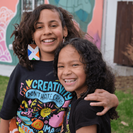 Picture of two girls side hugging and smiling