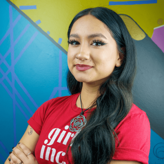 Portrait of a young woman smiling with a red Girls Inc. of Metro Denver shirt