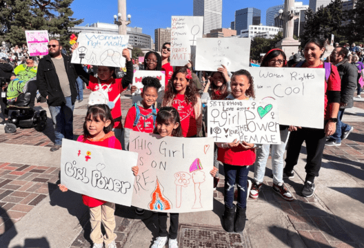 A group of young girls holding various pro-girl signs and signs about women's rights