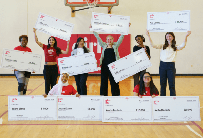 9 teen girls smiling and holding scholarship checks