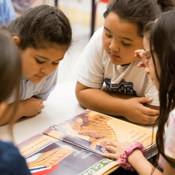 Elementary school aged girls reading a book