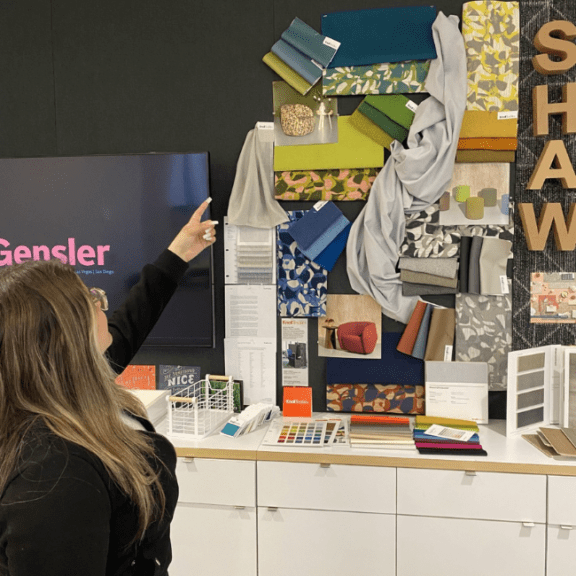 A teen interning at an interior design firm points at textiles.